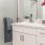 Bath with single vanity and large mirror with plenty of light.