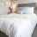 Bedroom with large bed, ensuite. queen bed and nightstands.
