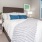 Bedroom with large bed, ensuite. queen bed and nightstands.